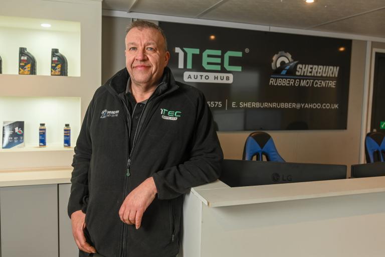 Image of Sherburn Rubber Owner in reception with 1TEC Auto Hub signage displayed