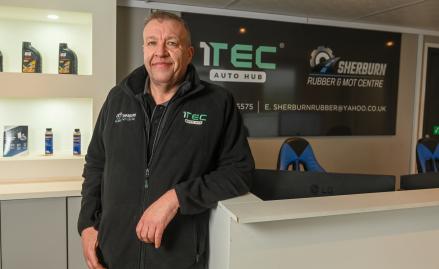 Image of Sherburn Rubber Owner in reception with 1TEC Auto Hub signage displayed